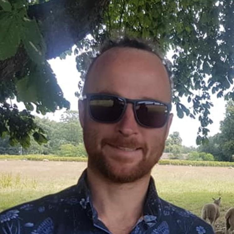 Headshot of the post author outdoors in sunglasses